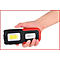 Een hand houdt een zwart-rode LED-werklamp vast. Op de lamp staat een bedrijfslogo en de naam "KS TOOLS".